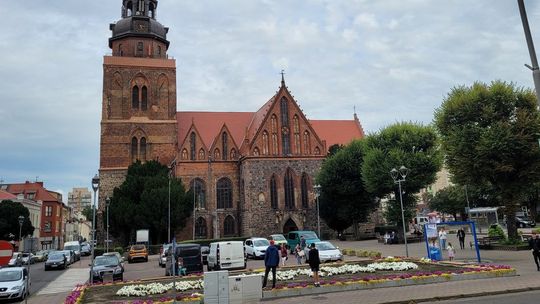 Turyści próbują odczytać kwiatowy napis