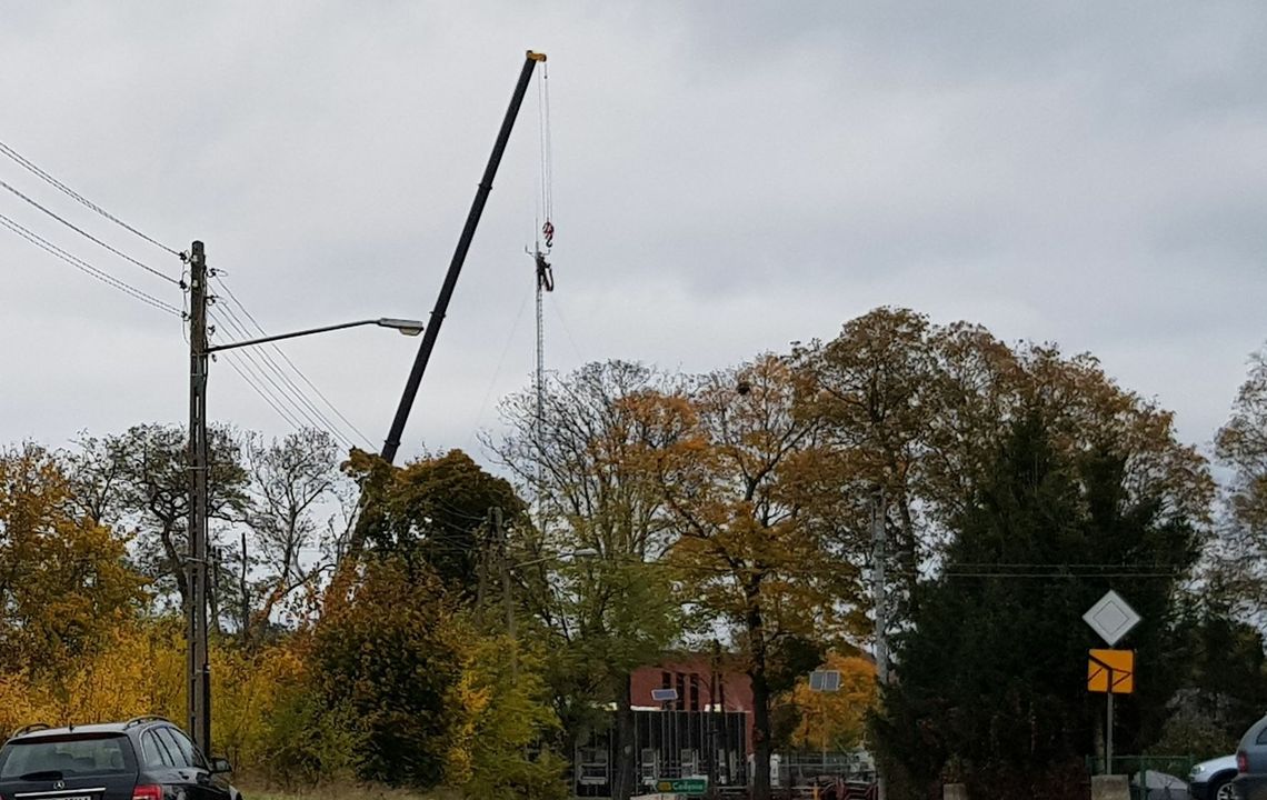 Człowiek wisiał kilkadziesiąt metrów nad ziemią. Budynek policji z masztem