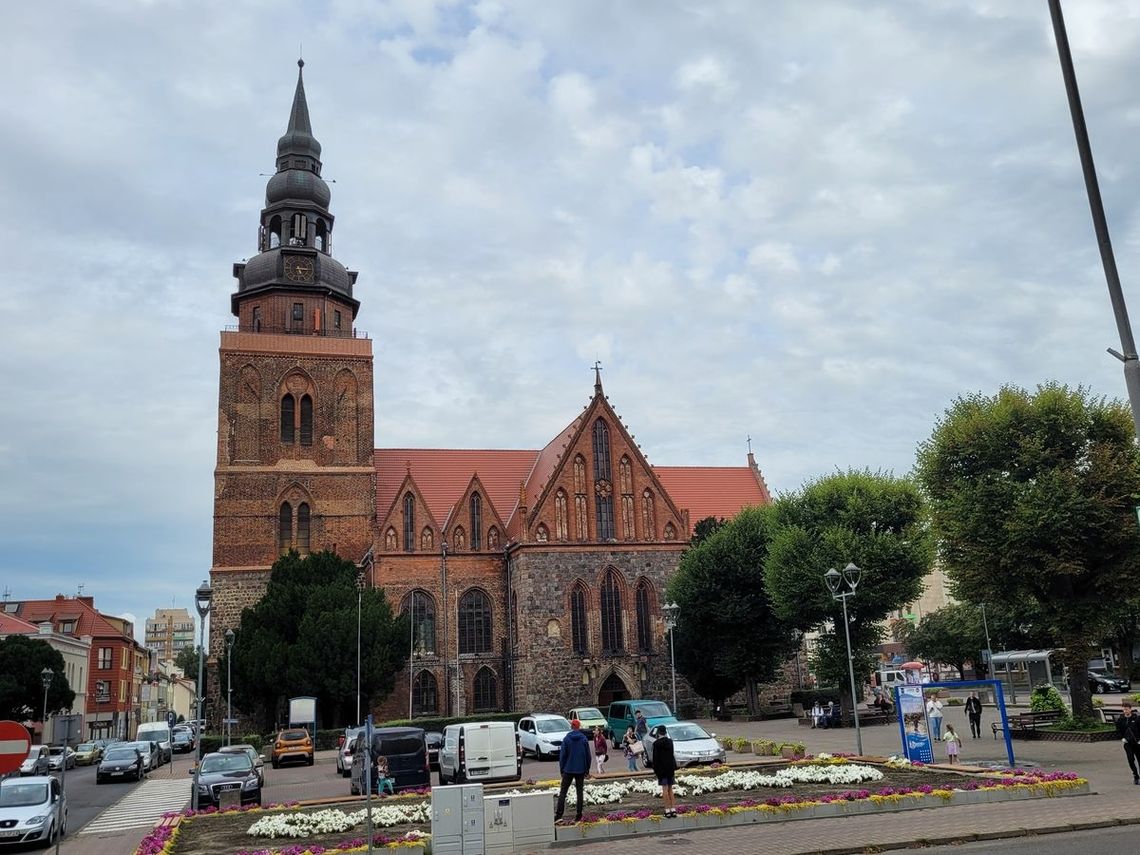 Turyści próbują odczytać kwiatowy napis